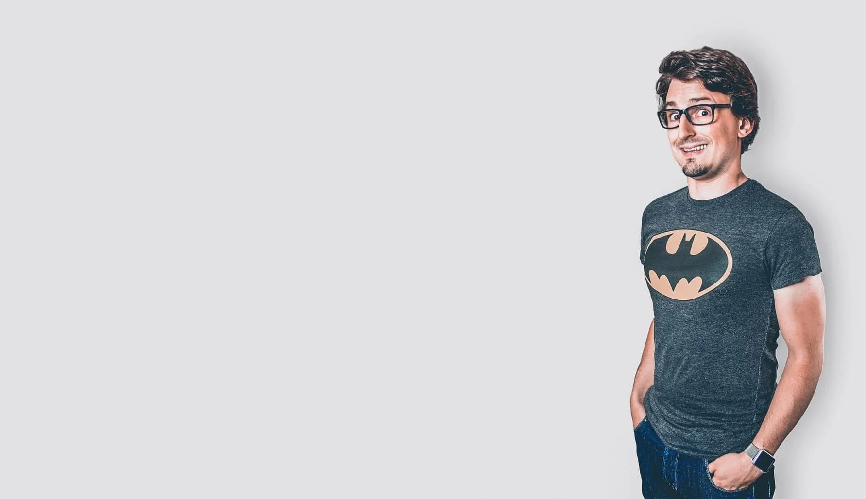 Andreas Zeitler in a Batman T-shirt, smiling, hands in his pockets